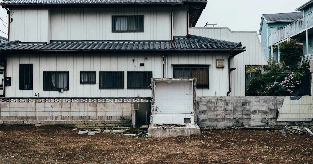 解体後の更地と、隣の建物との境に残る壁